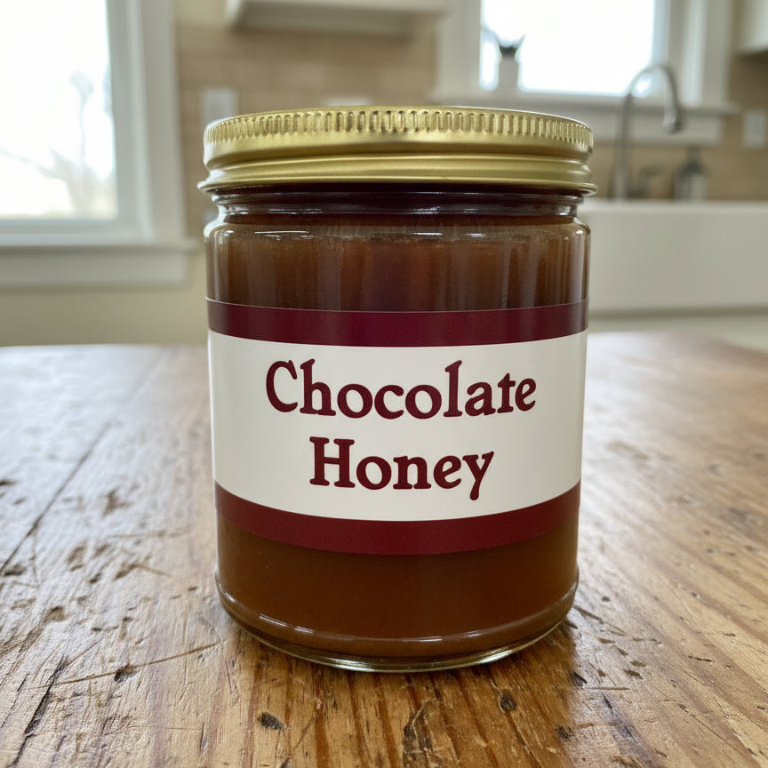 Jar of chocolate honey with a gold lid on a white surface